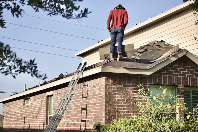 Professional roofer working on a residential roof in Driver